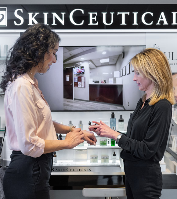 employee and patient looking at skin care products